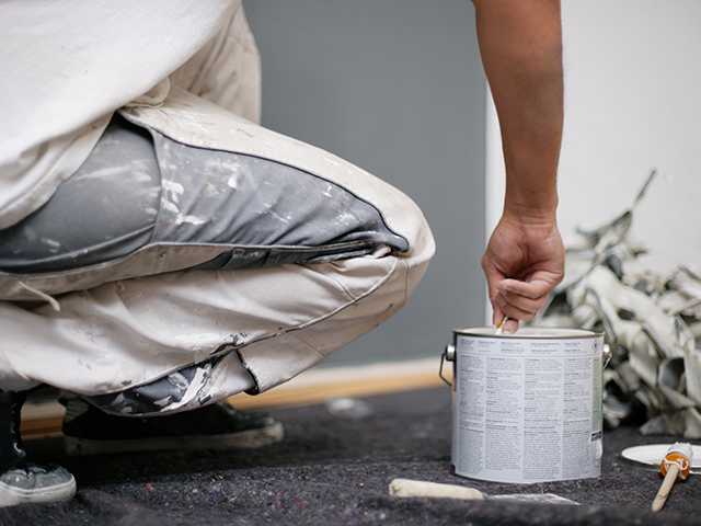 Handwerker misst Holz präzise. Steht für Planung und die Notwendigkeit eines übersichtlichen Kontos für Handwerker bei der Deutschen Bank. 4.	Bild 4 (drittes Bild, Malen):