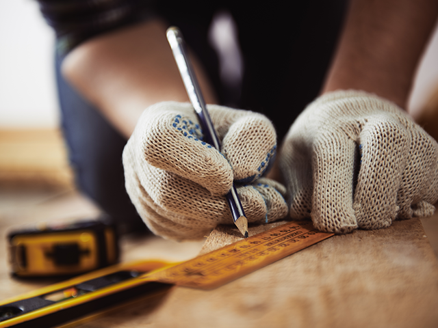 Handwerker mauert Ziegel. Symbolisiert solides Handwerk und den Bedarf an einem verlässlichen Deutsche Bank Geschäftskonto für Handwerk.
