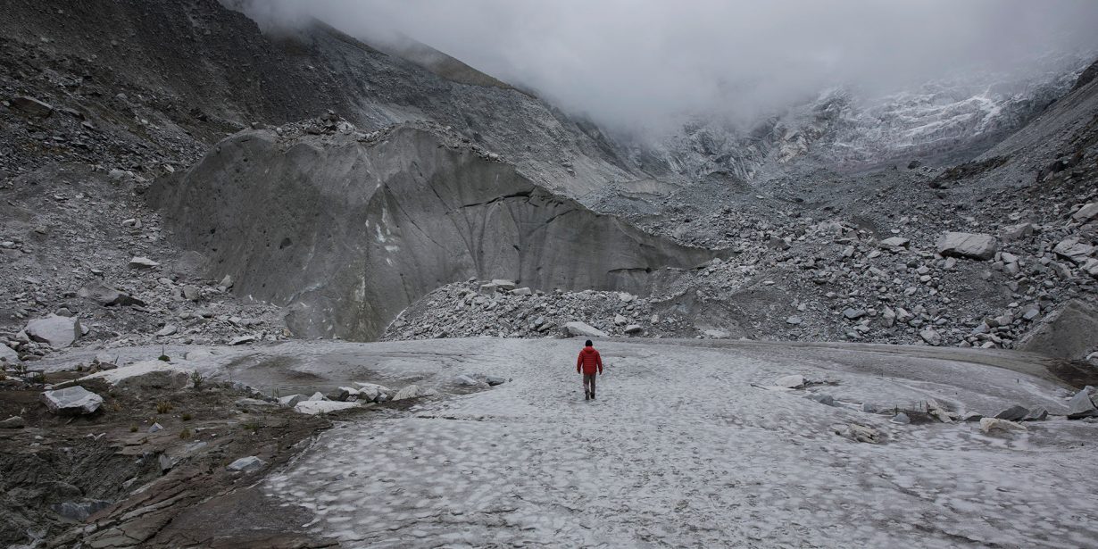 Mann vor Gletscher im Nebel