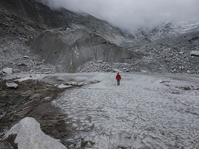 Mann vor Gletscher im Nebel