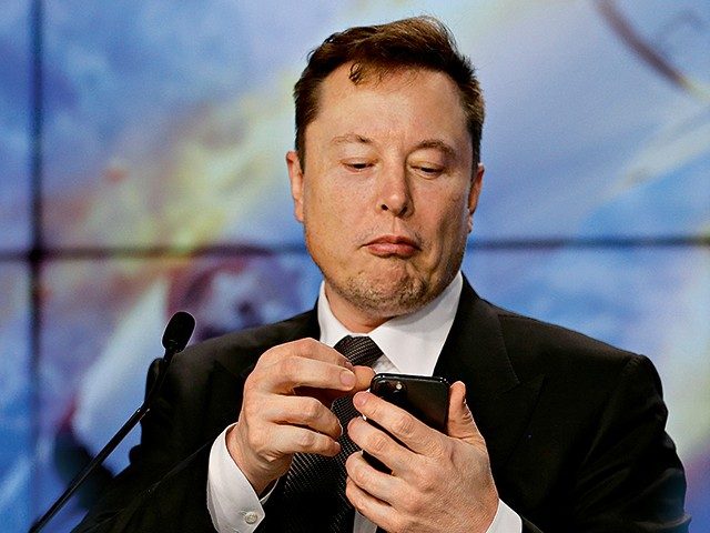Elon Musk sieht auf sein Smartphone