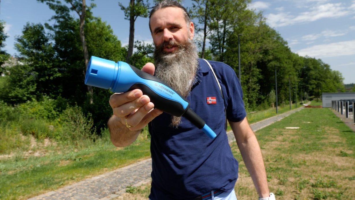 Mann streckt Stecker in die Kamera