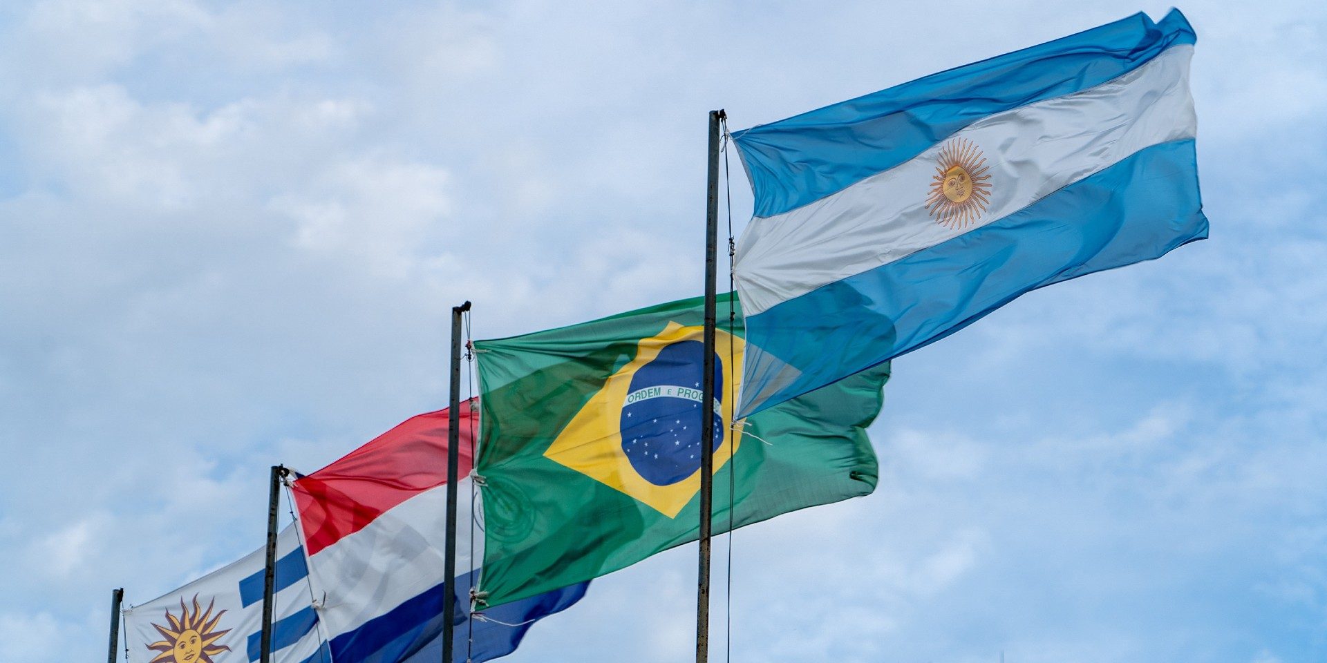 Flaggen der Mercosur-Staaten Argentinien, Brasilien, Paraguay und Uruguay wehen im Wind.