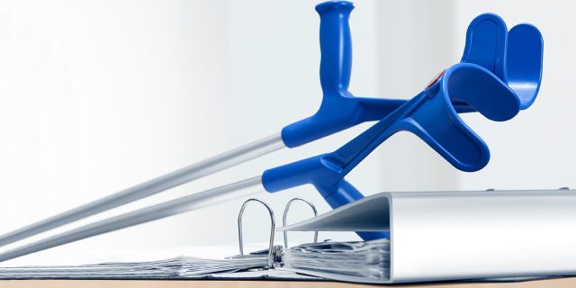 Ein Paar Krücken auf einem Aktenordner