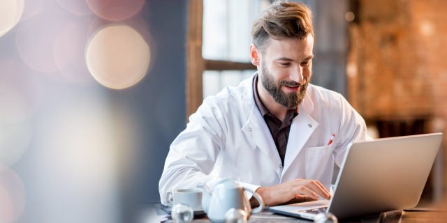 Ein Arzt vor einem Laptop