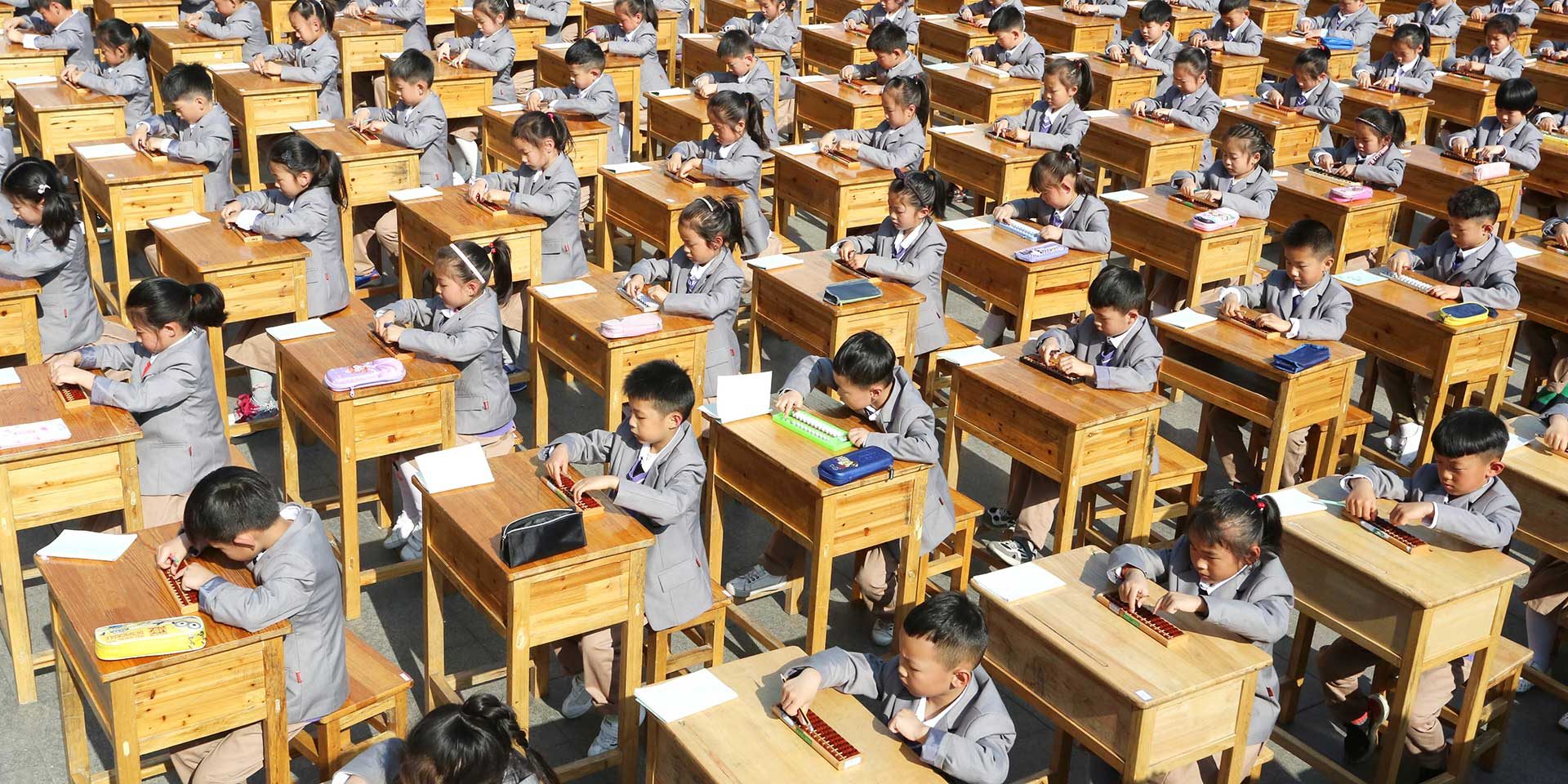 Sie sind (noch) keine Kreditanalysten, aber sie erarbeiten sich das Rüstzeug: Chinesische Schulkinder rechnen mental mit einem Rechenschieber. Die Bestimmung der Kapitaldienstfähigkeit ist am Ende auch nichts anderes als eine Kombination von Marktverständnis und Mathematik.