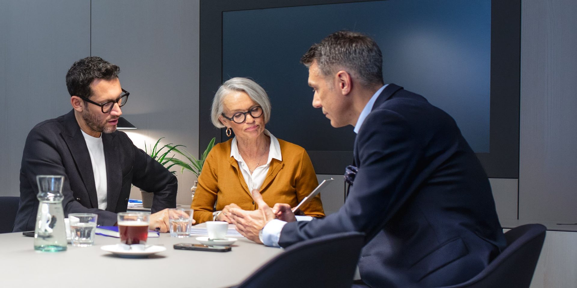 Berater der Deutschen Bank mit Unterlagenmappe in der Hand im Gespräch.